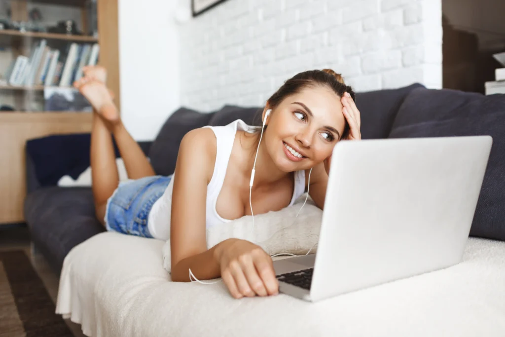 Mujer disfrutando de una conexión WiFi estable gracias a un amplificador de señal mientras usa su portátil en el sofá.